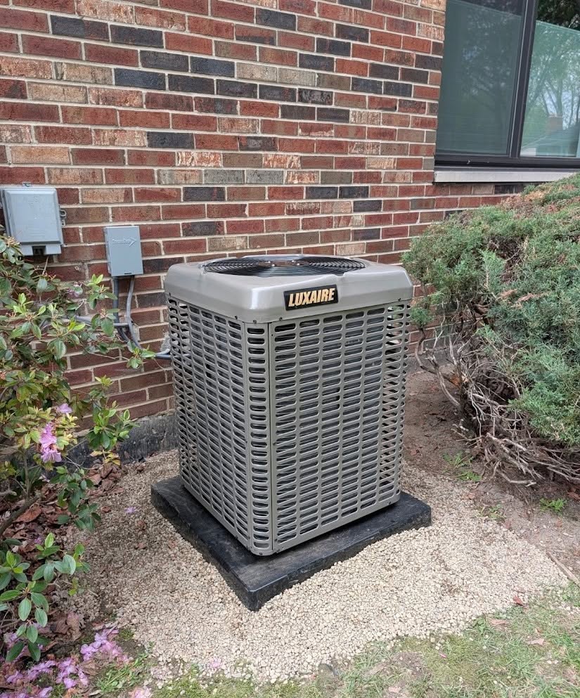 New Luxaire outdoor HVAC system installed beside a brick home