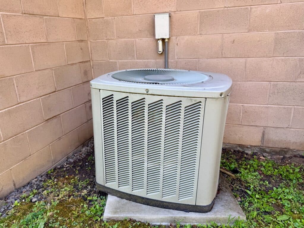Older outdoor air conditioning unit evaluated for repair or replacement